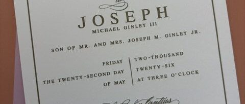 Letterpress wedding invitation with a gold border and embossed Cleveland skyline